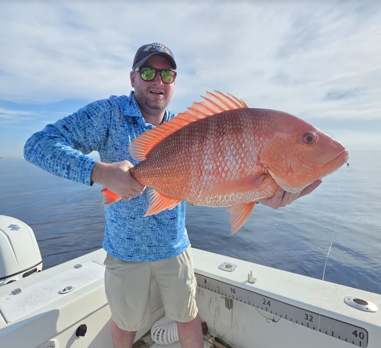 Strike Mission customer holding a red snapper
