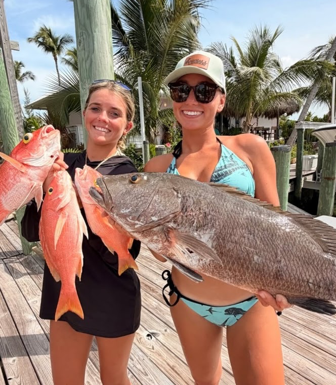Two anglers holding snapper after a Strike Mission fishing charter